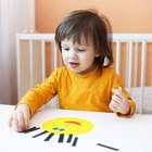 Baby girl (18-24 months) looking in mirror, hands pressed on glass