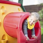 Toddler boy kicking red ball