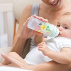 Close Up Of Mother Cuddling Sleeping Baby Daughter At Home