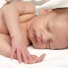 Close-up of a baby boy holding the railing of a crib