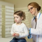 Closeup of caring mother holding head on sick daughter forehead