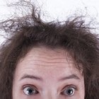 woman straightening hair with straightener . rear view