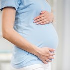 Woman in exercise clothes, pushing three-wheeled baby carriage