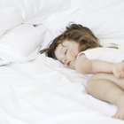 Cheerful girl sleeping with her teddy bear