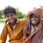 Family with two children sitting in front house