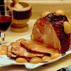 Delicious smoked ham on a wooden board with spices.