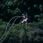 Man bungee jumping, seen against blue sky, view from below