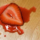 Ripe tomatoes and glass of tomato juice on wooden table