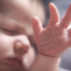 sleeping baby in hand of mother