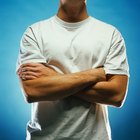 Businessman standing in hallway of office, arms crossed