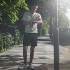 Mid adult man standing at street, looking at watch