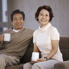 Couple sitting at table in bar, toasting with champagne, smiling