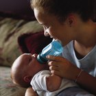 Three bottles of milk on top of blanket or bib