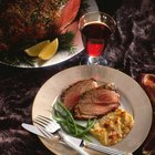 Roasted meat and savory sauce with fork on plate, close-up