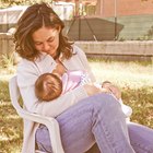 Mother Sitting on Her Porch Kissing Her Sleeping Newborn Baby