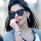 Laughing woman holding earrings in shop