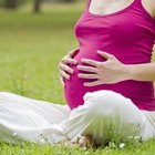 Pregnant woman holding pills and glass of water