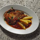 Two raw pork chops arranged for prep cooking