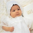 girl (11-13) standing praying wearing her first holy communion dress
