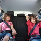 Girl (6-8 years) sitting on rear seat of car, close-up, side view