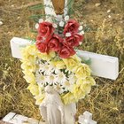 Mature woman placing red rose on gravestone in cemetery