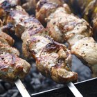 Raw lamb leg on blue stone background with herbs