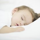 Hispanic father sleeping on sofa with baby