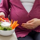 Midsection Of Pregnant Woman Holding Milk Glass