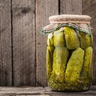 marinated cornichons in wooden bowl