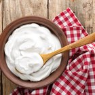 Greek yogurt in glass jars with wooden spoon on wood table