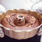 Strawberry cake in a white serving dish on a wooden surface