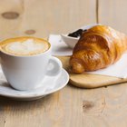 Croissants, coffee, jam and fruits. Continental breakfast table top view