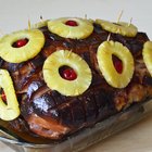 Delicious smoked ham on a wooden board with spices.