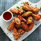 different flavored chicken wings on wooden table