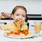 Mother preparing pizza with kids