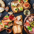 Various raw meats on rustic serving board