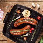 grilled bratwurst sausages with sauce, spinach and garlic