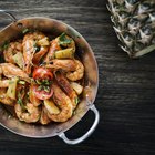 Plate with fried shrimp and rice, with wineglass in background, close-up