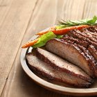 Cuts of warm, pink roast beef on a wooden surface