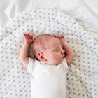 Little baby with bottle in white bed