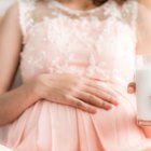 Pregnant women drinking orange juice at bedroom