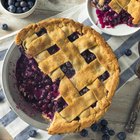 Slice of apple pie on paper on wooden table