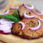 Fried liver with onions and apples on a concrete background