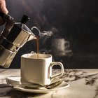 Bowls of uncut and ground coffee beans on blue wooden table
