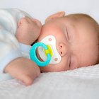 elevated close up view of a baby (6-12 months) sleeping with a dummy in its mouth