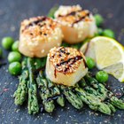 Fried scallops with sesame seeds, asparagus  and  lemon