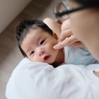 Woman looking down at baby sleeping