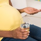 Pregnant Woman Hand With Glass Of Water And Vitamin Pill