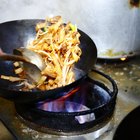 Pouring food oil in hot pan for deep frying.