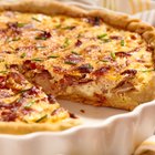 Asparagus quiche on white wooden surface